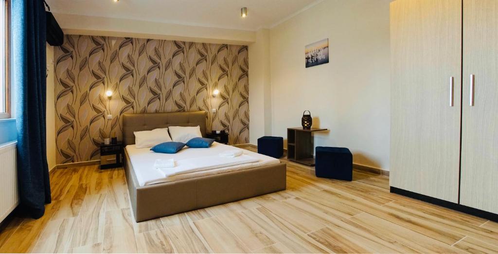 布加勒斯特毕赞特新旅馆的一间卧室配有一张带蓝色枕头的床。