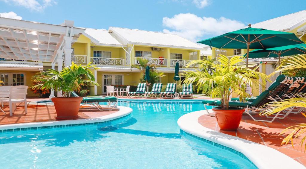 格罗斯岛海湾花园酒店的度假村的游泳池,配有椅子和遮阳伞