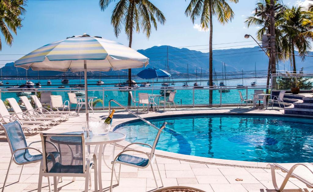 伊利亚贝拉伊利亚贝拉酒店的一个带桌椅和遮阳伞的游泳池