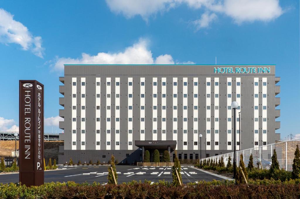 宇都宫Hotel Route-inn Utsunomiya Yuinomori -Lightline Yuinomori Nishi-的建筑前有标志的酒店