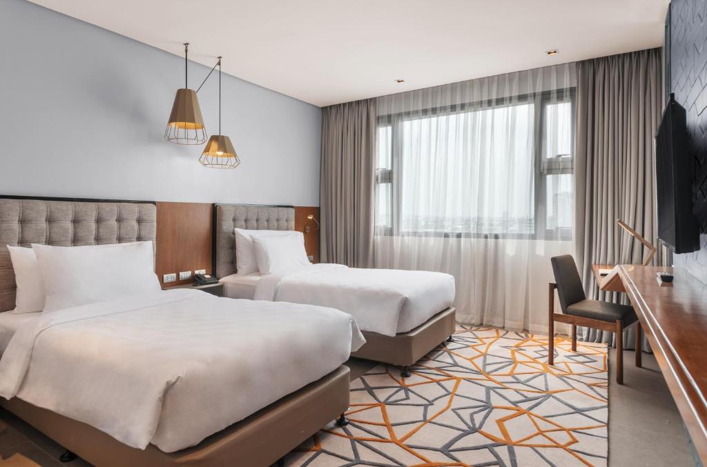 宿务Summit Galleria Cebu的酒店客房配有两张床和一张书桌