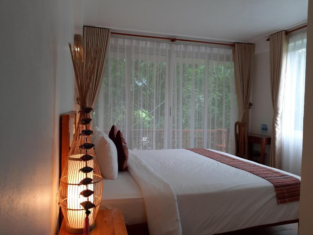 枚州县Mai Chau Dreams Homestay的一间卧室设有一张床和一个大窗户