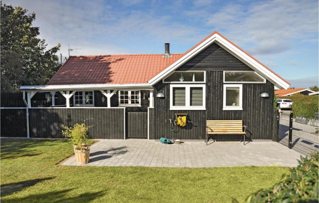 尼堡Cozy Home In Nyborg With Kitchen的黑色房子,带长凳和围栏