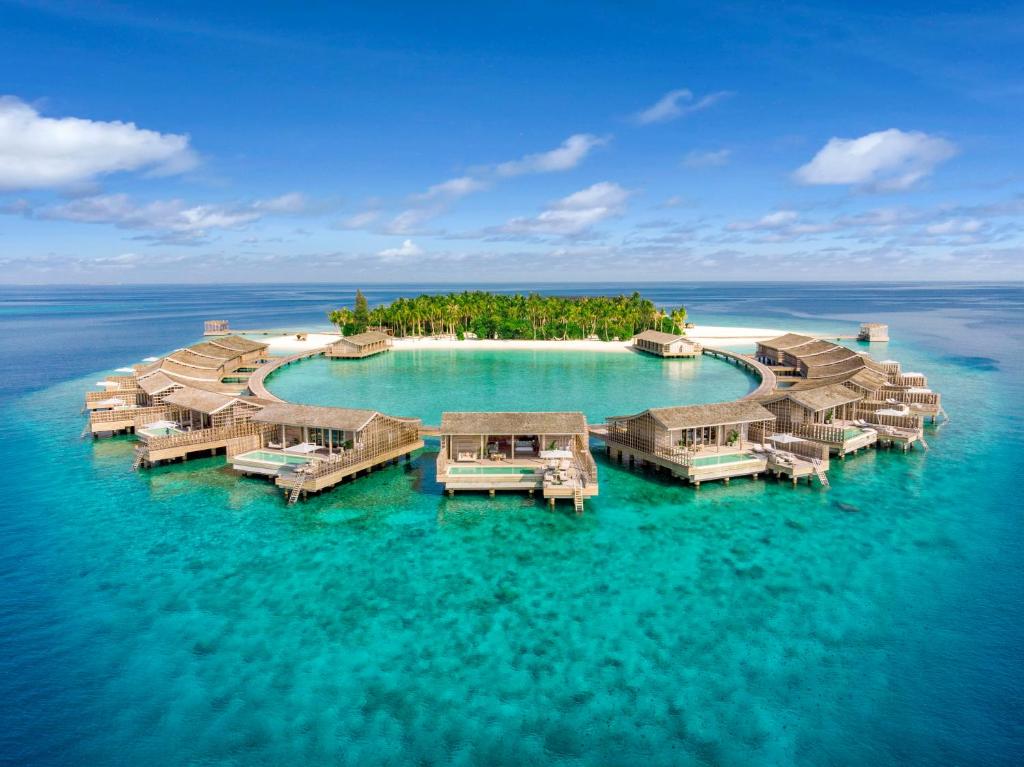 拉薇亚妮环礁Kudadoo Maldives Private Island – Luxury All inclusive的海洋中的一座岛屿,设有水上简易别墅