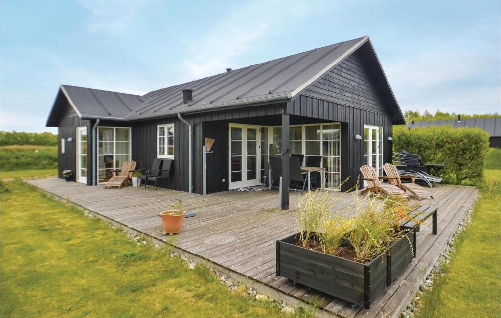 尼斯泰兹Stunning Home In Nysted With Wifi的一座黑色房子,在院子里设有木甲板