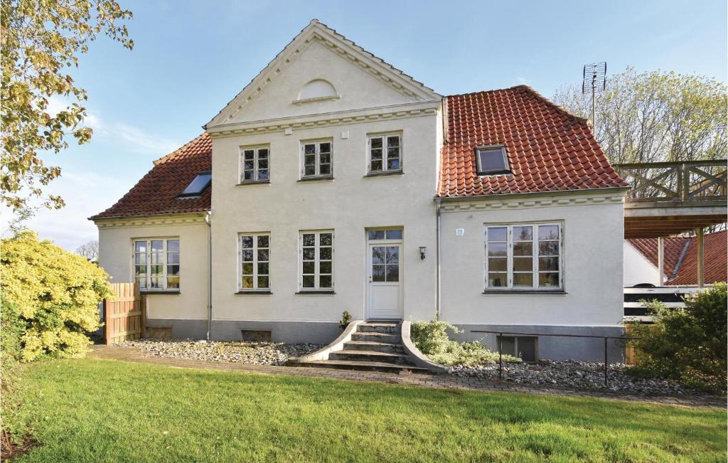 ÅrøAwesome Home In Assens With Sauna, Internet And Indoor Swimming Pool的白色房子,有红色屋顶