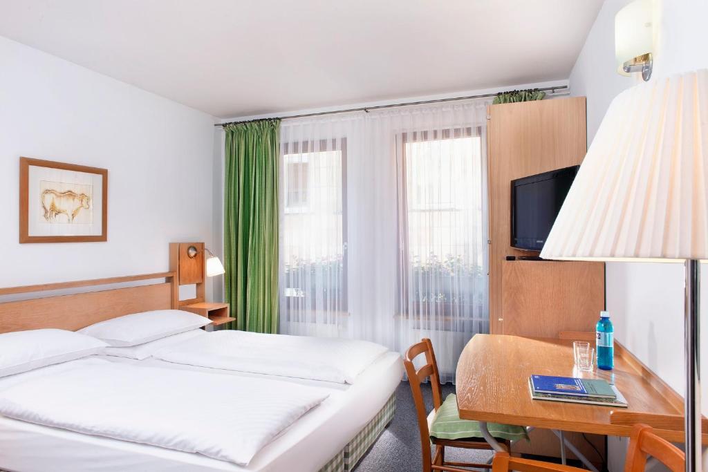 纽伦堡纽伦堡阿格尼斯舍弗酒店的酒店客房配有一张床和一张带电脑的书桌