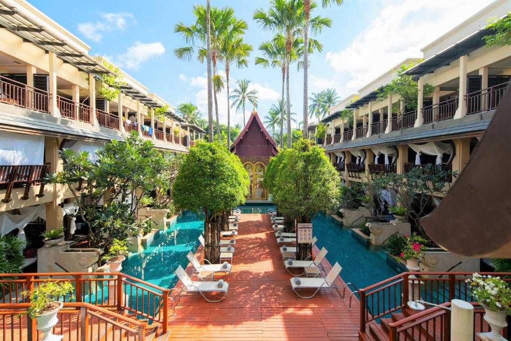 芭东海滩Burasari Phuket Resort & Spa的一座空无一人的酒店庭院,里面设有游泳池和棕榈树