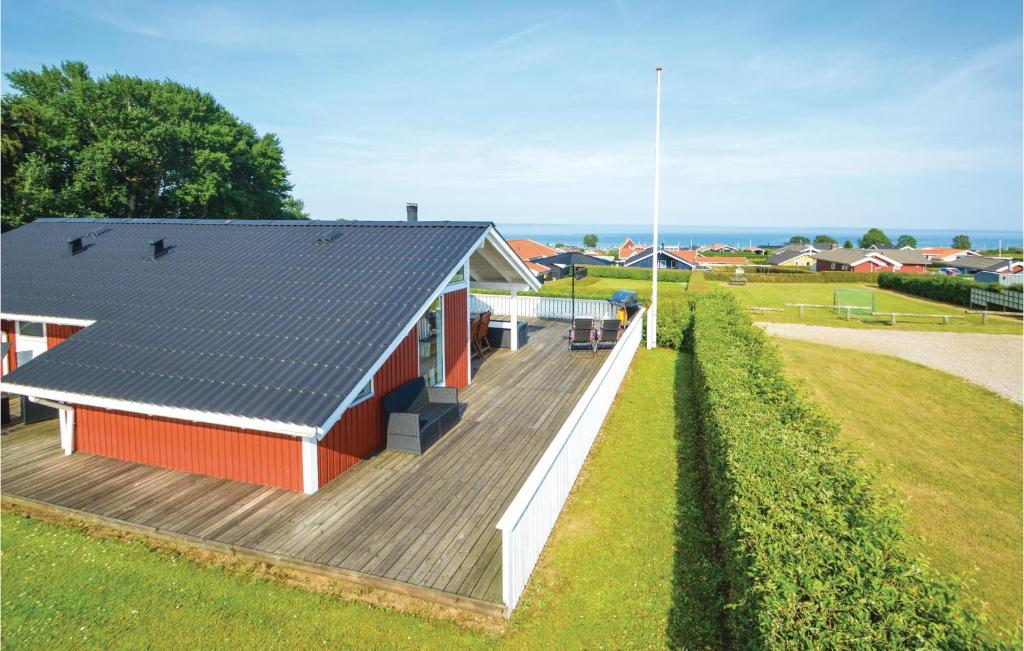 桑德比耶特Amazing Home In Sjlund With Wifi的一座红色的小建筑,设有木甲板