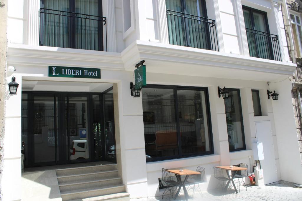 伊斯坦布尔Liberi Hotel Taksim的前面有两张桌子的建筑