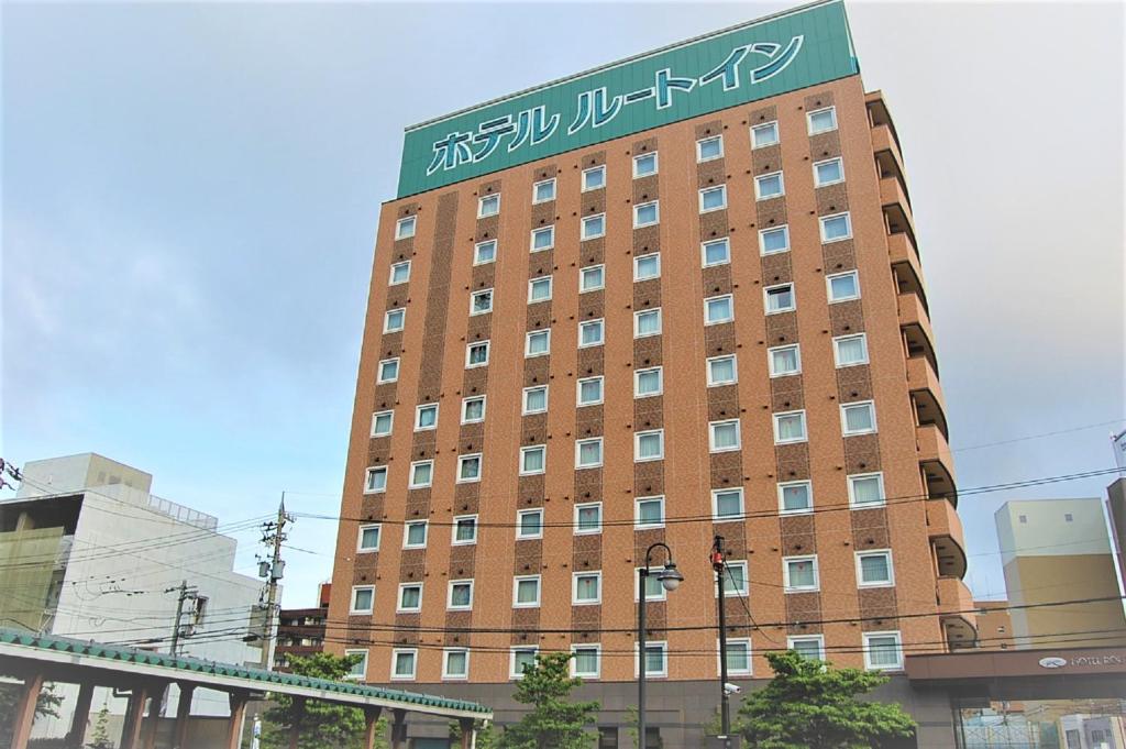 敦贺市敦贺站前路线酒店的一座高大的砖砌建筑,上面有标志
