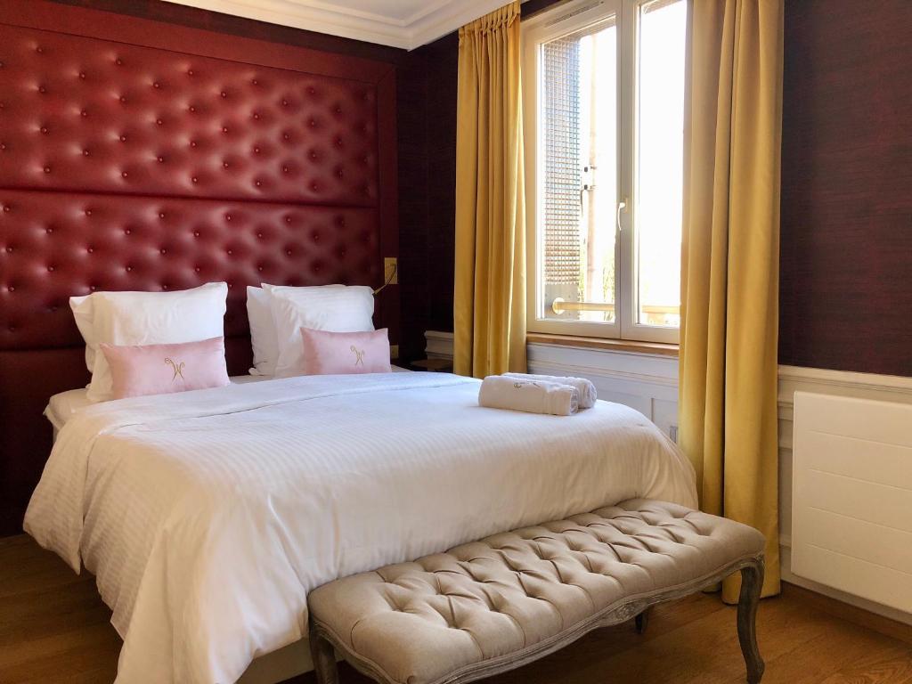 敦刻尔克Les chambres du Waterzooi的一间卧室配有一张大床和红色床头板