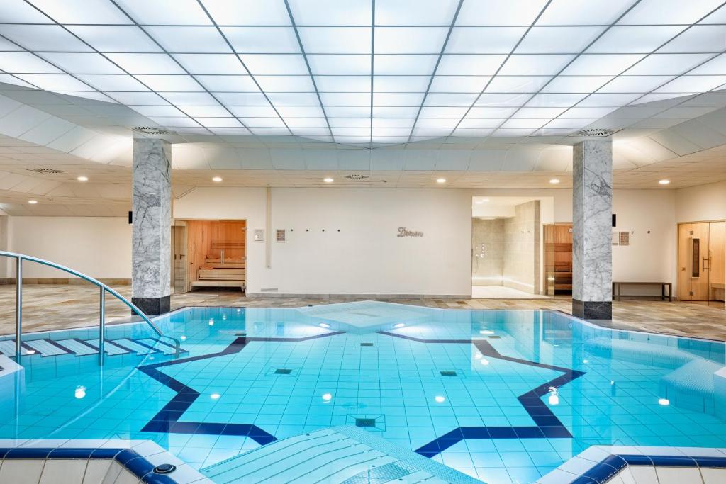 下恩豪森尼登豪森威斯巴登H+酒店的一个带天花板的房间内的大型蓝色游泳池
