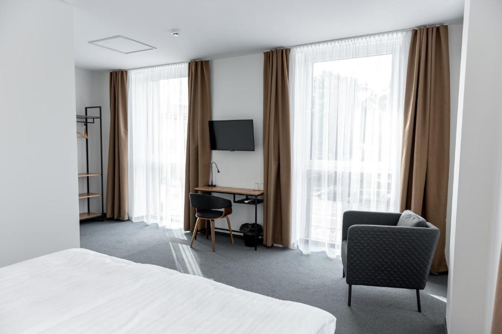 ŠilalėMuontis的酒店客房设有一张床、一张书桌和窗户。