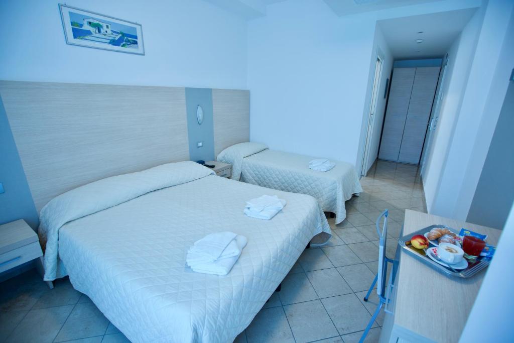 里米尼Hotel Etoile的酒店客房带两张床,还有蓝色的灯光