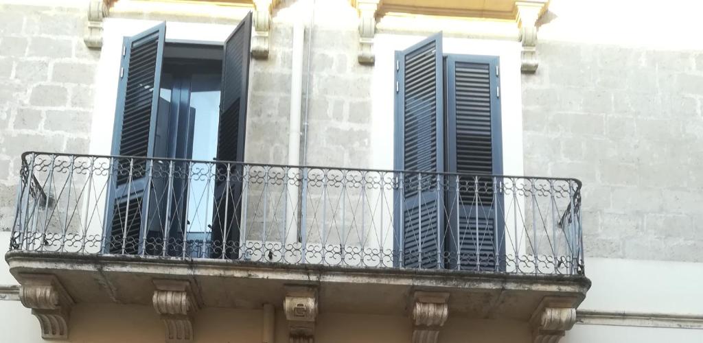 圣维托诺曼La casa della nonna in Salento的带阳台的大楼设有三扇窗户