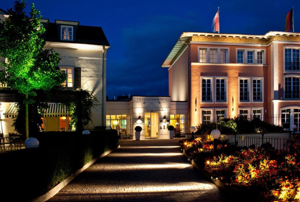 班贝格Hotel Villa Geyerswörth的一座白色的大建筑,晚上有灯
