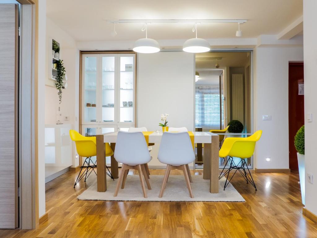 萨格勒布Apartman Delux Adda的一间带桌子和黄色椅子的用餐室