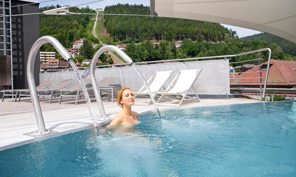 巴特维尔德巴德莫科尼帕莱斯Spa酒店的屋顶游泳池里的女人