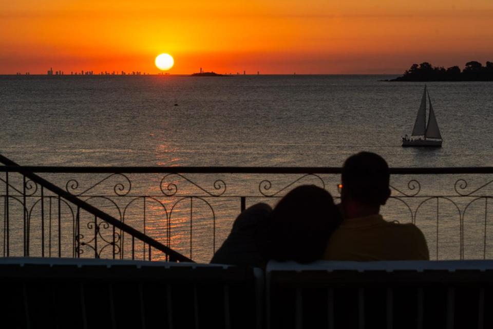 科洛尼亚-德尔萨克拉门托Casa Francis - Apartamentos的坐在长凳上的一对夫妇欣赏日落