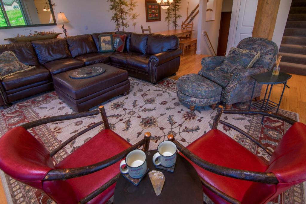 大天空市Saddle Ridge Townhome I-5的客厅配有真皮沙发和椅子