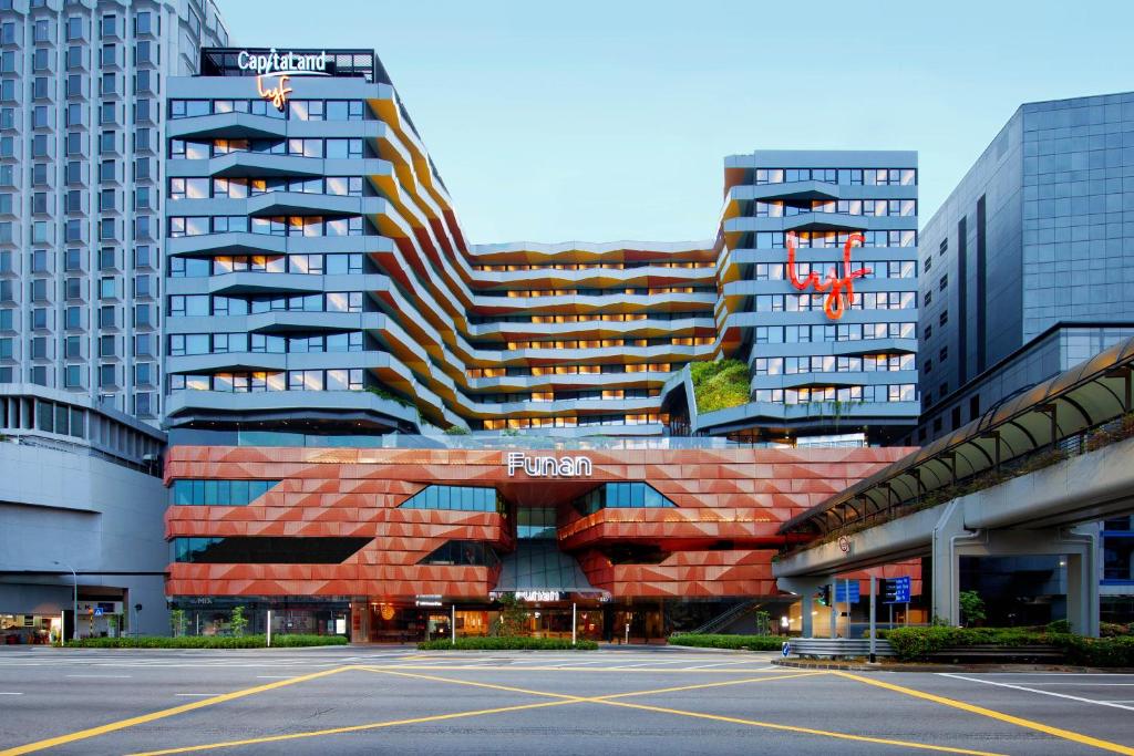 新加坡lyf Funan Singapore的一座大型建筑,前面设有停车场