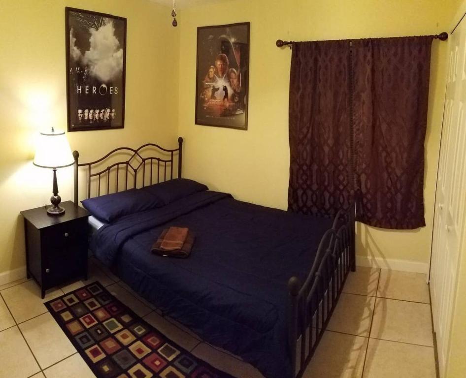 奥兰多B Private Bedroom的一间卧室配有一张带蓝色棉被的床