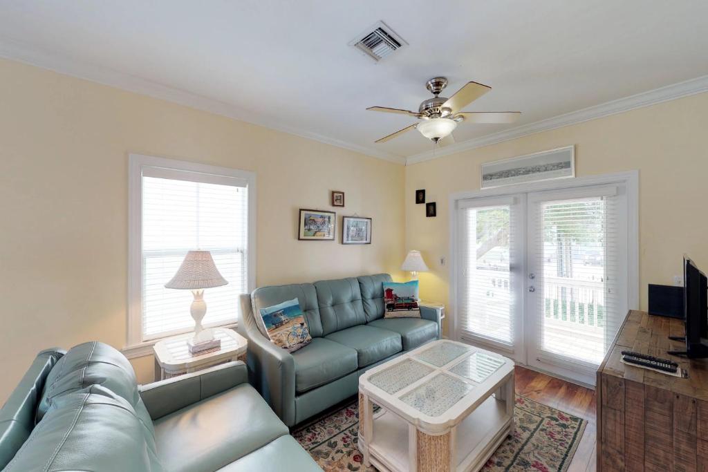 斯托克岛Hemingway Hideaway的客厅配有蓝色的沙发和吊扇