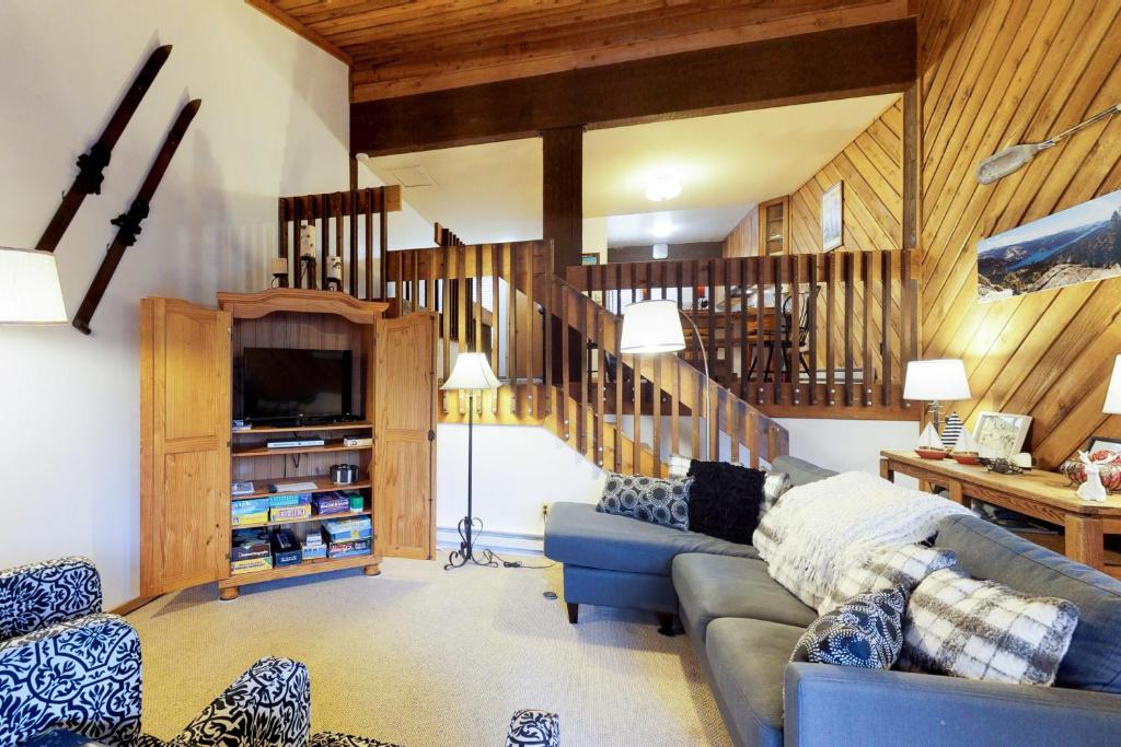 LakeshoreHuntington Lake Condo 12的客厅设有蓝色的沙发和楼梯。