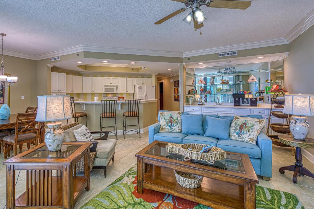 奥兰治比奇Phoenix on the Bay II的一间带蓝色沙发的客厅和一间厨房