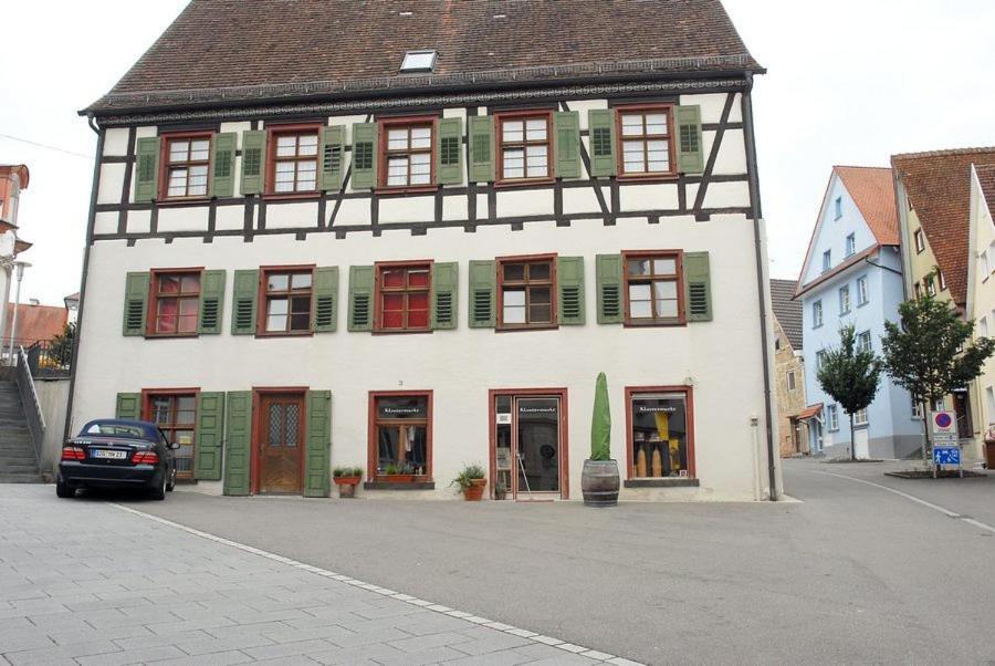 梅斯基希克洛斯特赫堡乡村民宿的街道上一座带绿色百叶窗的大型白色建筑