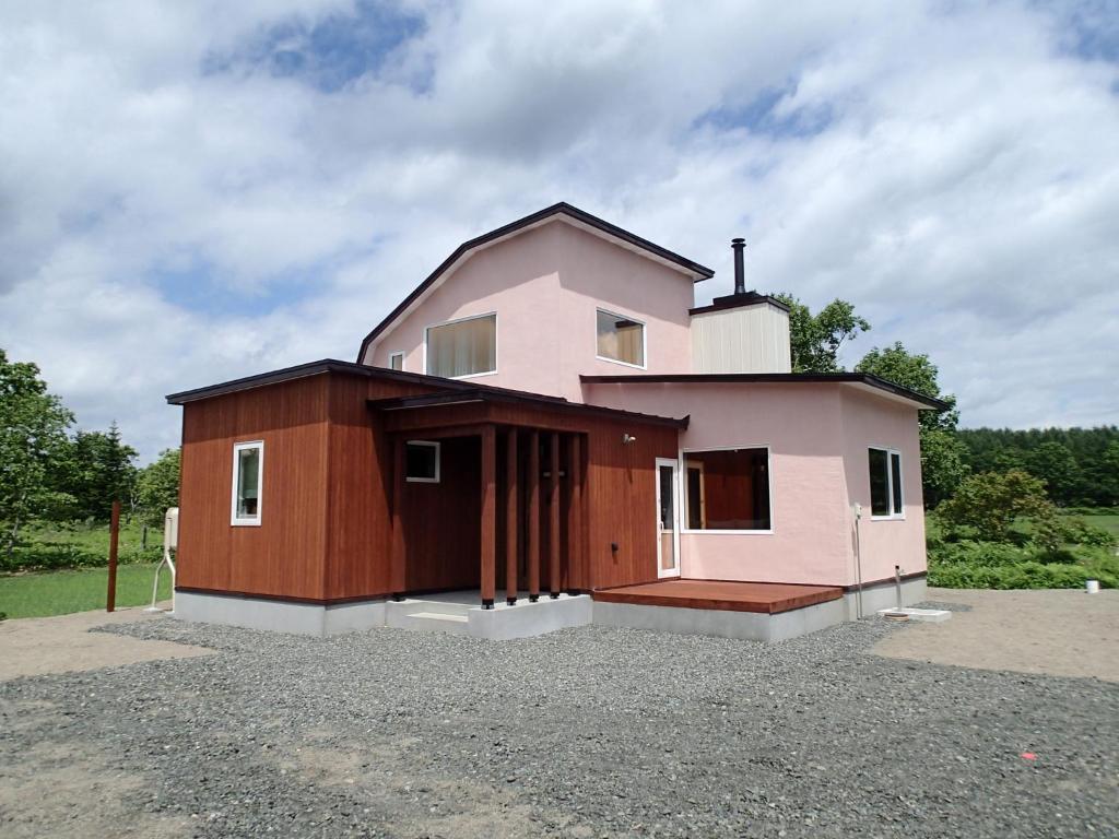 鹤居村Tsukushi Village的坐在很多地方的粉红色房子