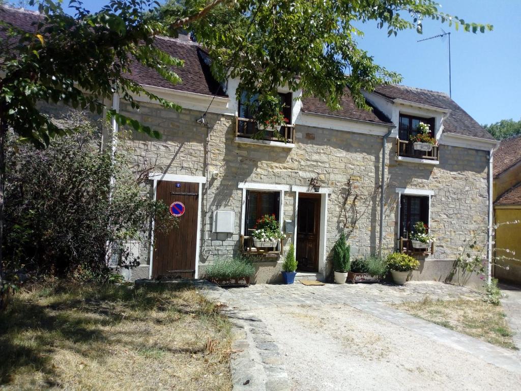 ReclosesCharmante Maison à Recloses的窗户上栽有盆栽植物的石头房子