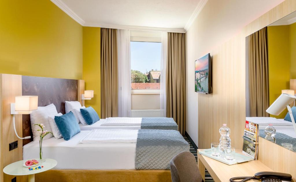 布达佩斯布达佩斯莱昂纳多酒店的酒店客房设有床和窗户。