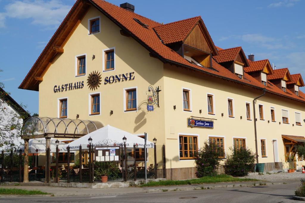 派森贝格Hotel Gasthaus Sonne的一座白色的大建筑,有红色的屋顶