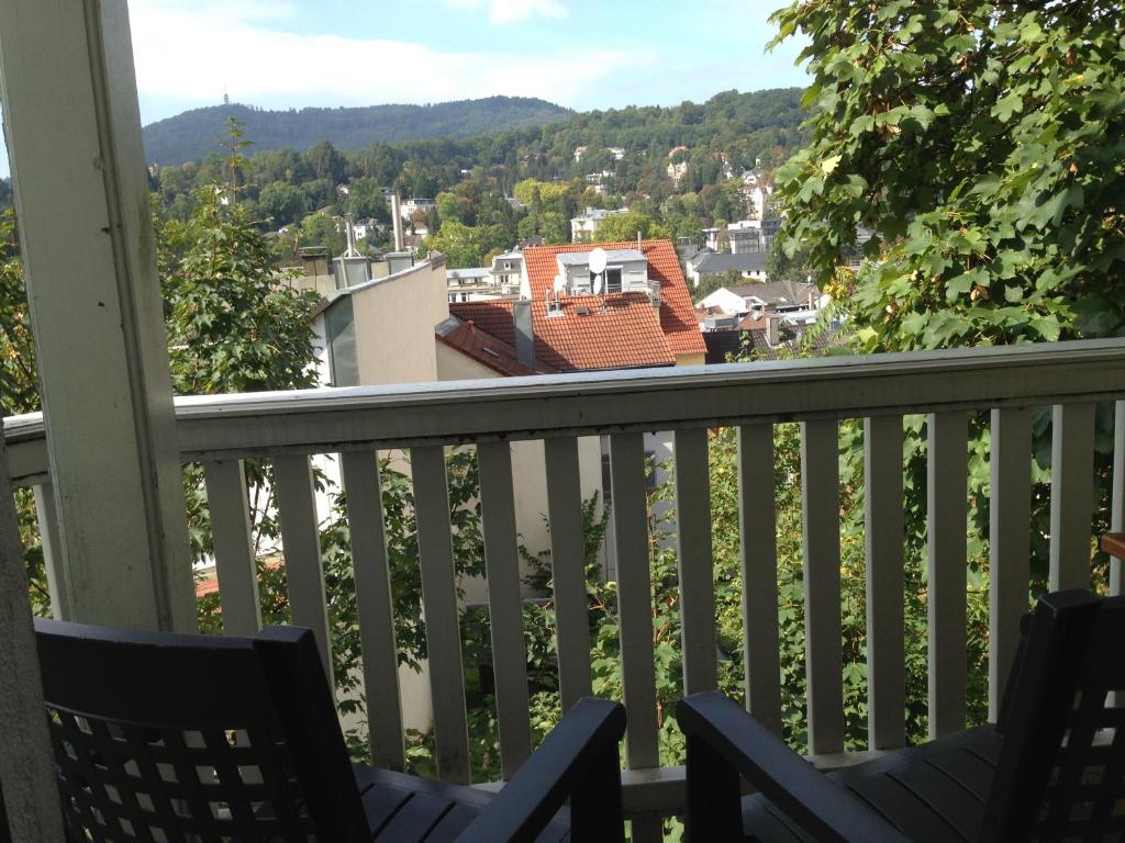 巴登-巴登派提布乐酒店的阳台配有椅子,享有城镇美景