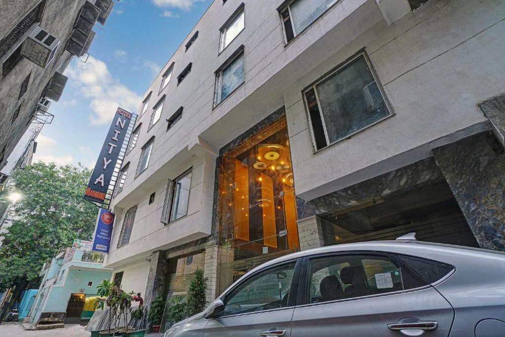 新德里Staybook Hotel Nitya Maharani, New Delhi, Paharganj的停在大楼前的汽车