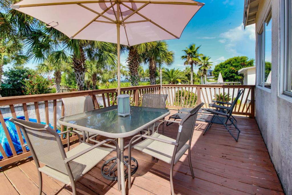 拉古纳海滩Linda's Cozy Cottage "C"的庭院配有桌椅和遮阳伞。