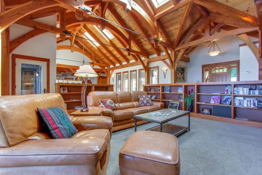 桑德波因特Bottle Bay Lakefront Lodge的客厅配有皮革家具和木制天花板
