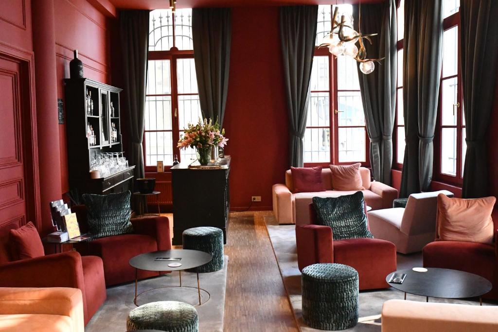 安特卫普T桑特酒店的客厅设有红色的墙壁和桌椅