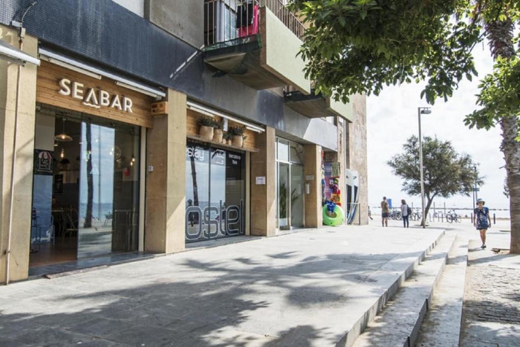 巴塞罗那Sea Hostel Barcelona的商店前的一条街道,人们沿着街道走