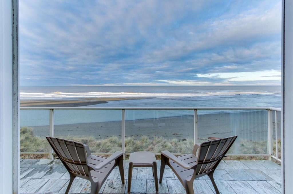 戈尔德比奇Ocean Lover's Landing的阳台上配有两把椅子和一张桌子,享有海景