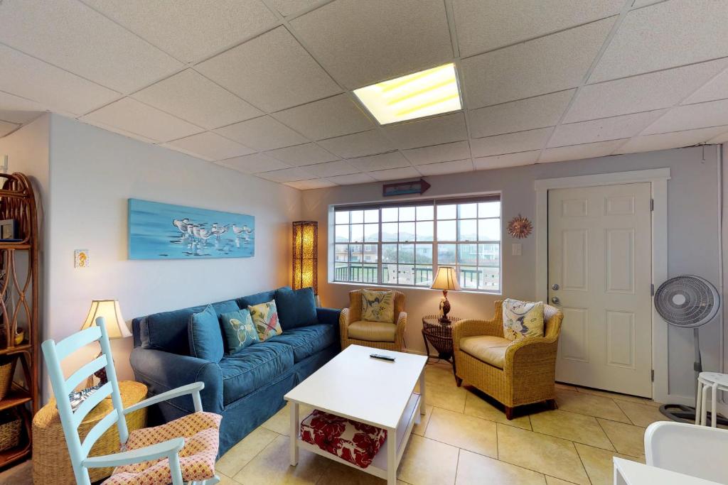 马士腾海滩Seaside Pearl的客厅配有蓝色的沙发和椅子