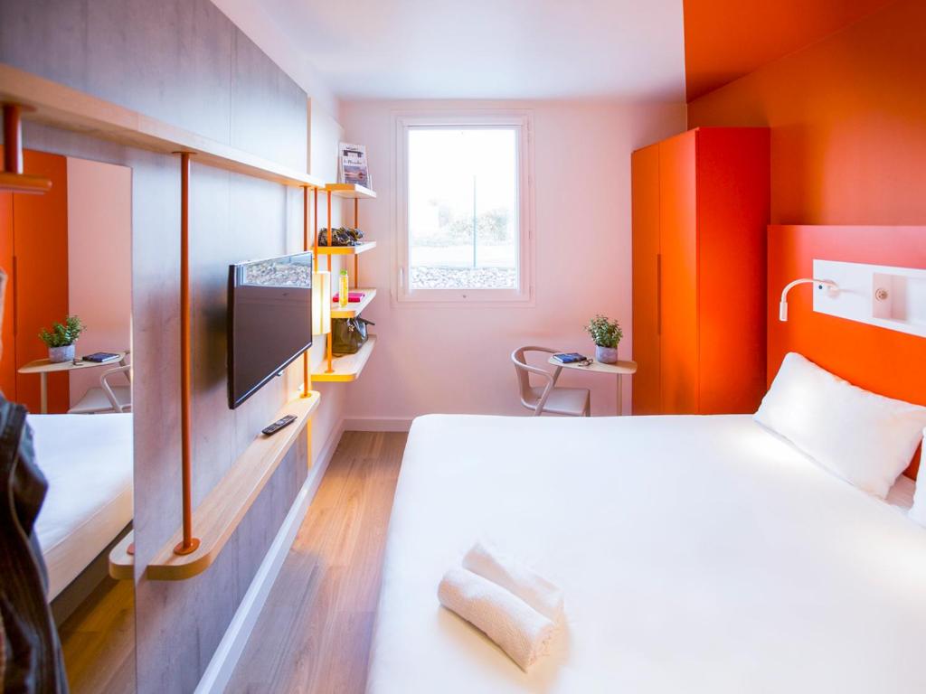 蒙彼利埃Ibis Budget Montpellier Nord Euromédecine的小房间设有床铺和电视