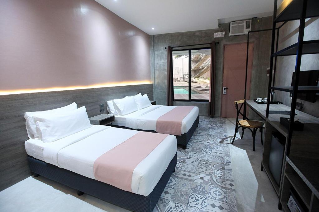 科隆Zenvea Hotel的酒店客房配有两张床和一张书桌