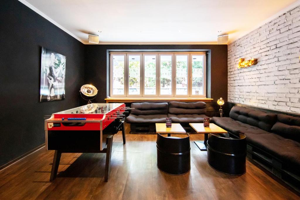 科隆Sonata City Hotel的客厅配有乒乓球桌和沙发