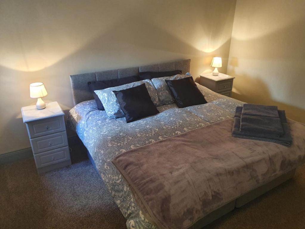 邓加文Junior Suite Town Centre的一间卧室配有一张带2个床头柜和2盏灯的床。