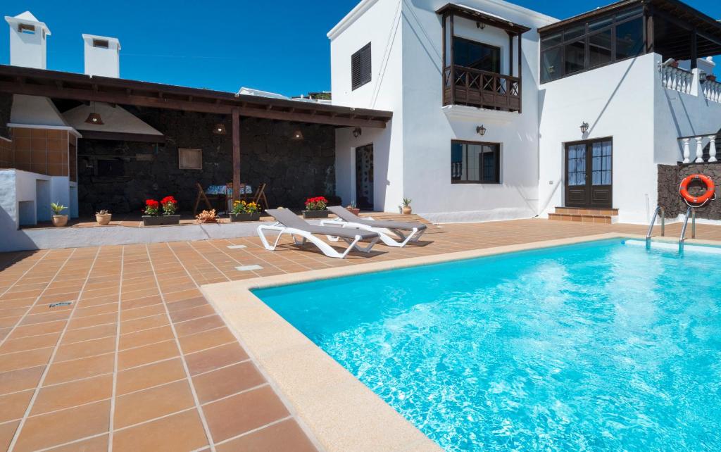 ConilApartamento Casa Belen的一座带游泳池和房子的别墅