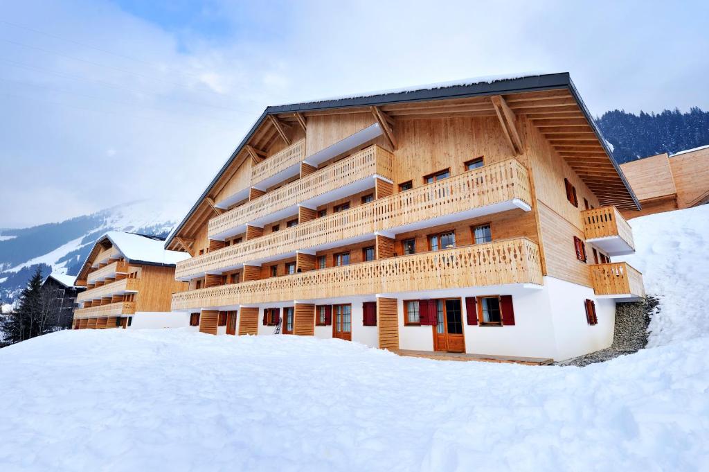 沙泰勒Résidence Néméa Le Grand Lodge的雪中一座大型木制建筑