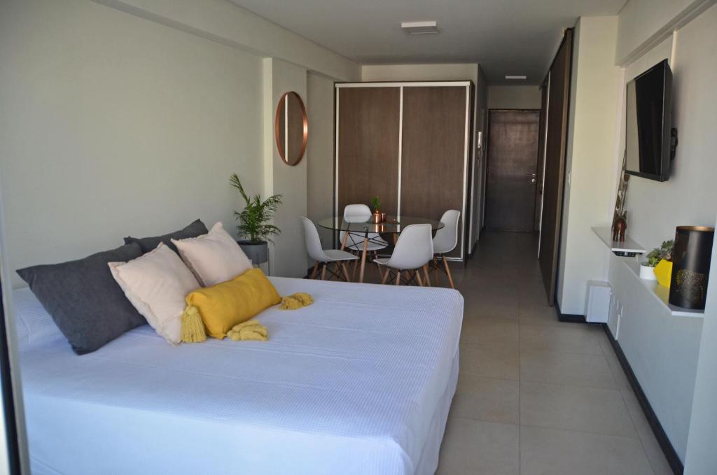 罗萨里奥CDM Temporal的卧室配有一张带黄色枕头的大型白色床。